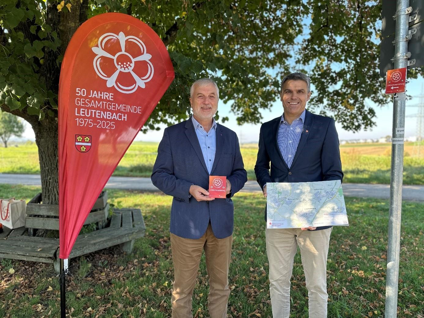 Markus Hofmeister, Filialdirektor der Kreissparkasse Waiblingen und Bürgermeister Jürgen Kiesl  zeigen ein Schild und die Wanderkarte des Wanderweges